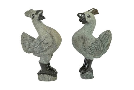 Stenen dieren beeld haan en kip in de woonkamer. Kip stenen kunst in huis. Grijze haan in de vensterbank.